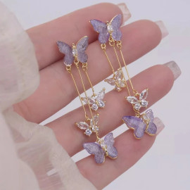 détail des boucles d'oreilles papillon en cristal violet